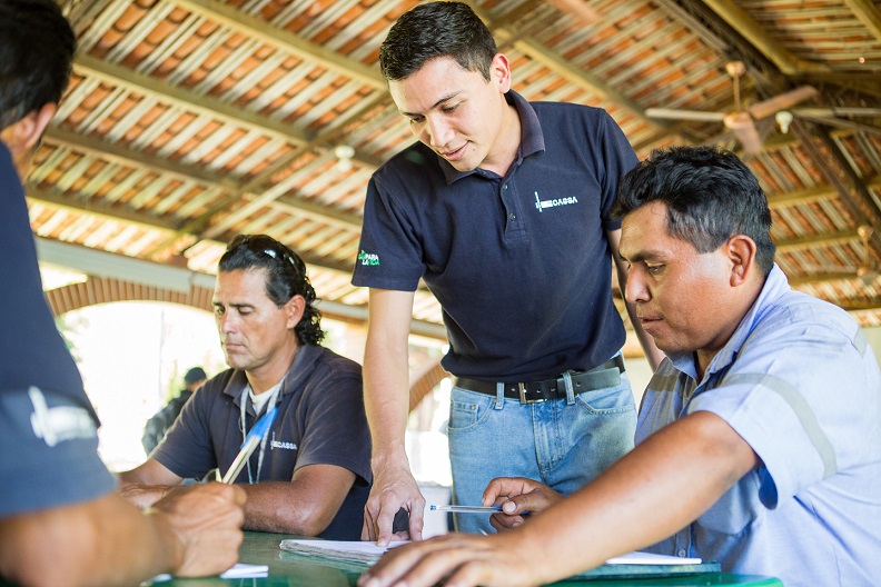 Mauricio Ortíz, colaborador de Grupo CASSA, enseña matemática a sus compañeros de trabajo, como parte del programa de voluntariado de la empresa.